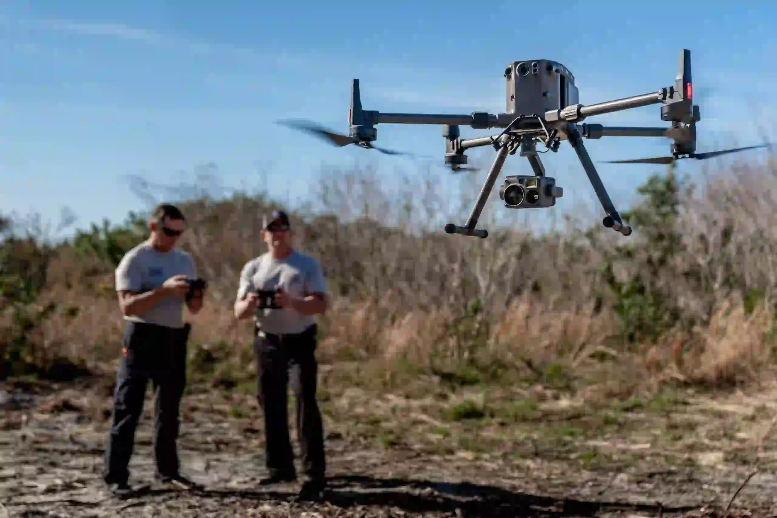 two men in the field controlling a drone